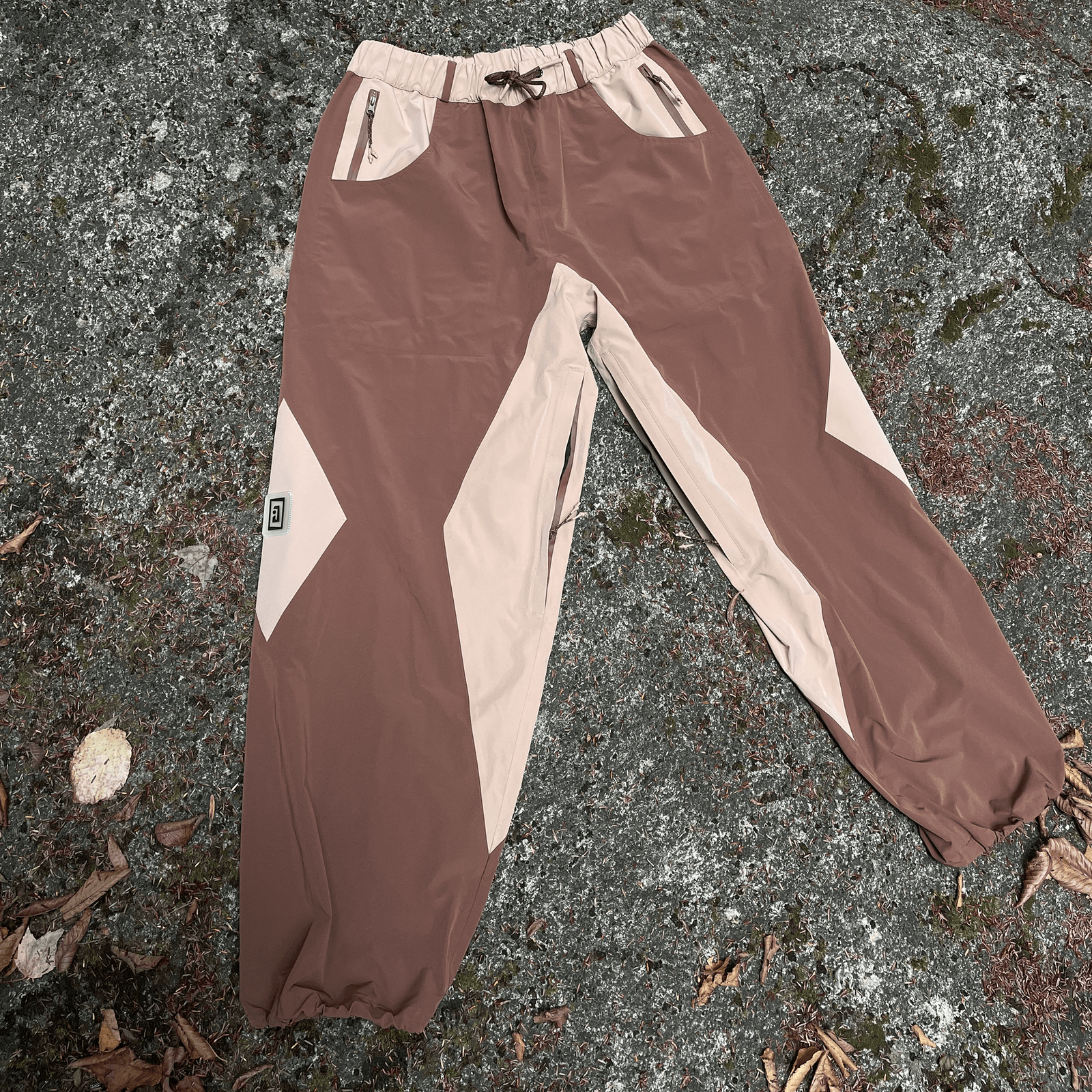 A brown pair of baggy snowpants, made for skiing and snowboarding. Baggy snowboard pants made out of a waterproof shell material